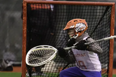 A lacrosse goalie reaching to make a save