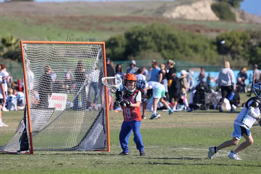 A lacrosse game in front of the goal